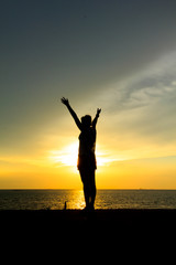 Fototapeta premium Silhouette of a woman against the sky at sunset
