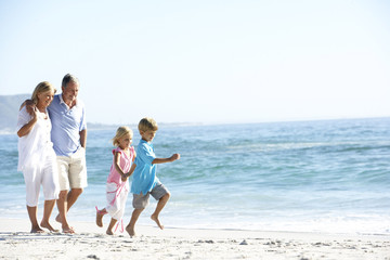 Grandparents and Grandchildren Walking Along Beach