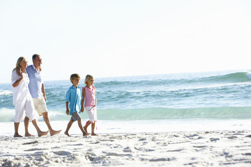 Grandparents and Grandchildren Walking Along Beach