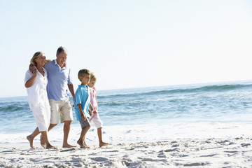 Fototapeta na wymiar Grandparents and Grandchildren Walking Along Beach