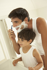 Son Watching Father Wet Shaving With Razor