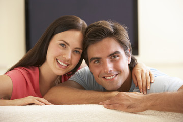 Couple Watching Widescreen TV At Home