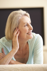 Senior Couple Watching Widescreen TV At Home