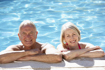 Senior Couple Relaxing In Swimming Pool Together