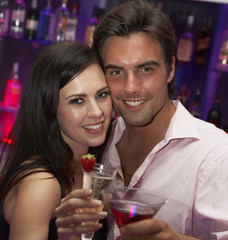 Young Couple Enjoying Drinks In Bar