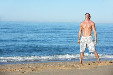 Young Man Standing On Summer Beach