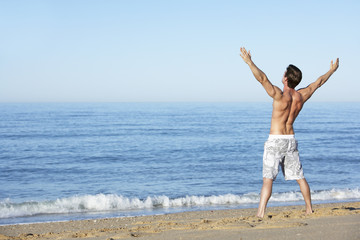 Fototapeta na wymiar Young Man Standing On Summer Beach