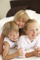 Group Of Children Relaxing On Bed
