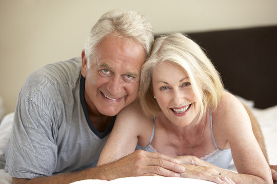 Senior Couple Relaxing On Bed