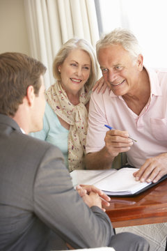 Senior Couple Meeting With Financial Advisor At Home