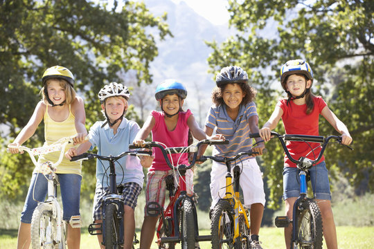 Group Of Children Riding Bikes In Countryside