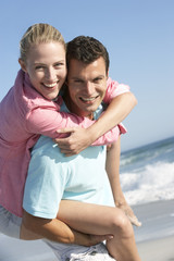 Fototapeta na wymiar Young Couple Having Fun On Beach