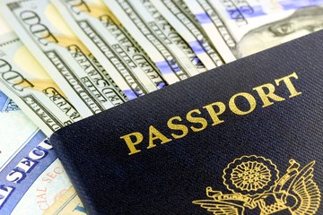 Travel Documents - United States passport with one hundred dollar bills