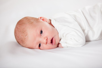 Newborn baby peacefully lying, on a white background