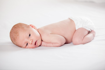 Newborn baby peacefully lying, on a white background