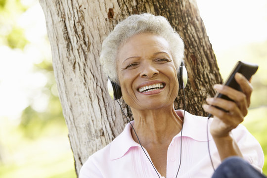 Senior African American Woman In Listening To MP3 Player