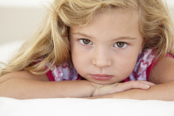 Young Girl Looking Sad On Bed In Bedroom