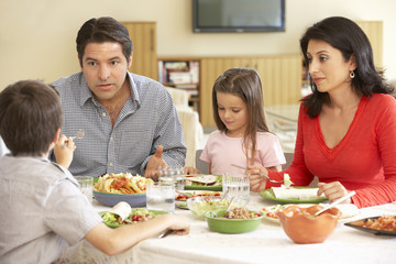 Obraz na płótnie Canvas Young Hispanic Family Enjoying Meal At Home