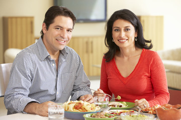 Young Hispanic Couple Enjoying Meal At Home
