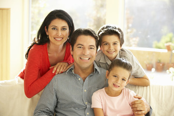 Obraz premium Young Hispanic Family Relaxing On Sofa At Home