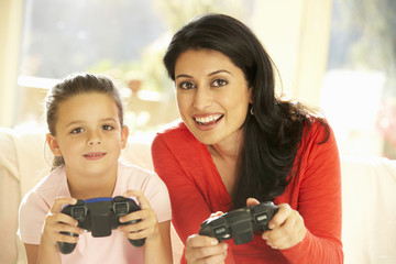 Mother And Daughter Playing Video Game At Home