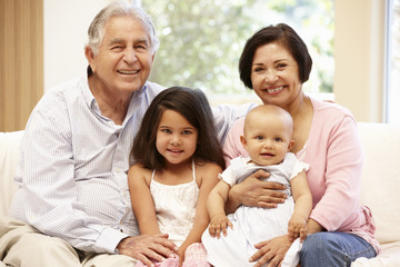 Hispanic grandparents at home with grandchildren