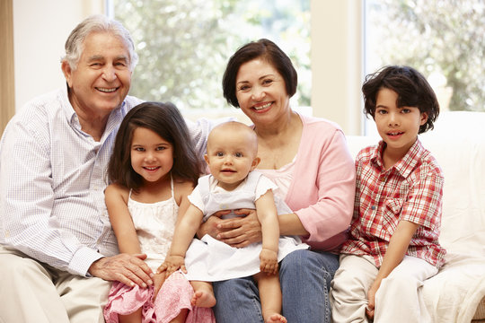 Hispanic Grandparents At Home With Grandchildren