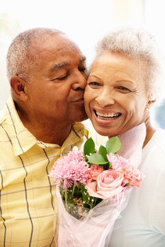 Senior Man Giving Flowers To Wife