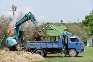 excavator is loading dirt on truck