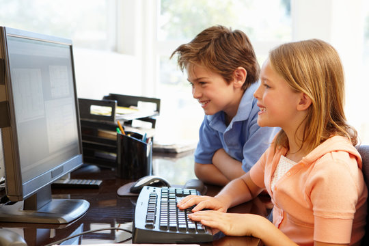 Young Boy And Girl Using Computer At Home