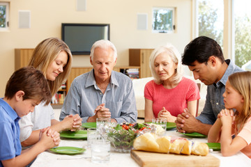 Obraz na płótnie Canvas Family saying grace before meal