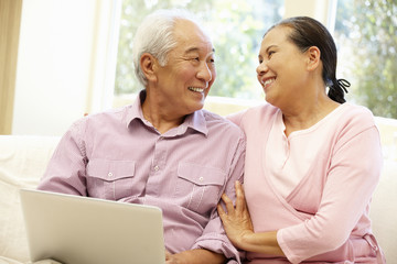 Senior Asian couple using laptop