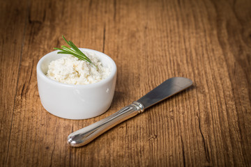 cream cheese in white bowl with knife