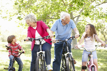 Obraz premium Senior couple with grandchildren on bikes