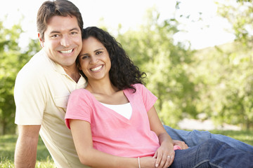 Obraz premium Romantic Young Hispanic Couple Relaxing In Park