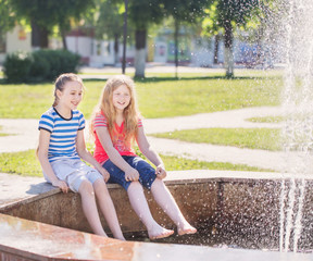 Fototapeta na wymiar two happy girls at the fountain