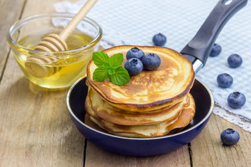 Stack of pancakes with blueberry and honey
