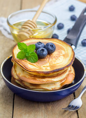 Stack of pancakes with blueberry and honey