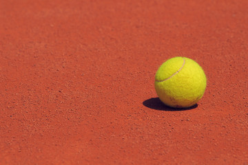 Tennis ball on a clay court.
