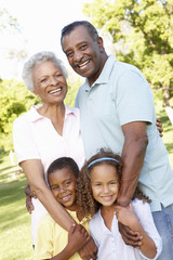 African American Grandparents With Grandchildren Walking In Park