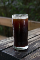 A glass of black iced coffee.