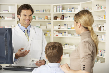 Pharmacist in pharmacy with mother and child