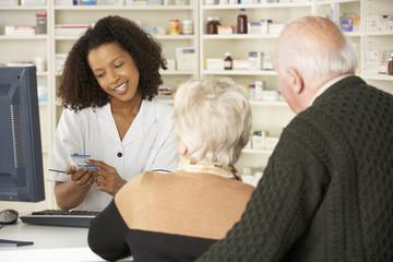 Pharmacien en pharmacie avec couple de personnes âgées