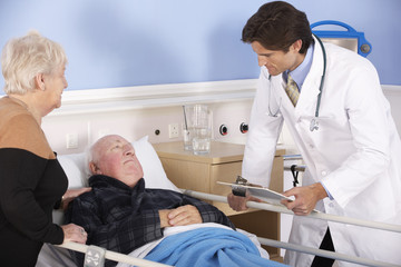 Obraz premium Doctor talking to senior couple in hospital