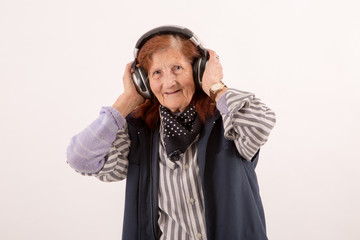 Elderly lady listening music with headphones.