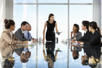 Group Of Business People Having Board Meeting Around Glass Table - obrazy, fototapety, plakaty