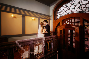 Obraz na płótnie Canvas Beautiful wedding couple is kissing in classic vintage interior