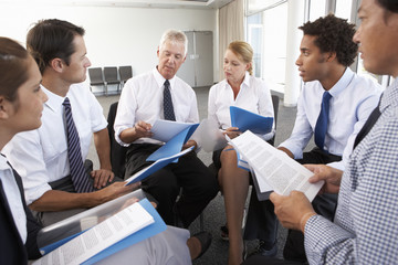 Businesspeople Seated In Circle At Company Seminar