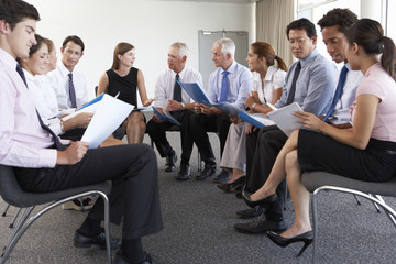 Businesspeople Seated In Circle At Company Seminar