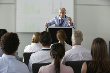 Middle Aged Businessman Delivering Presentation At Conference